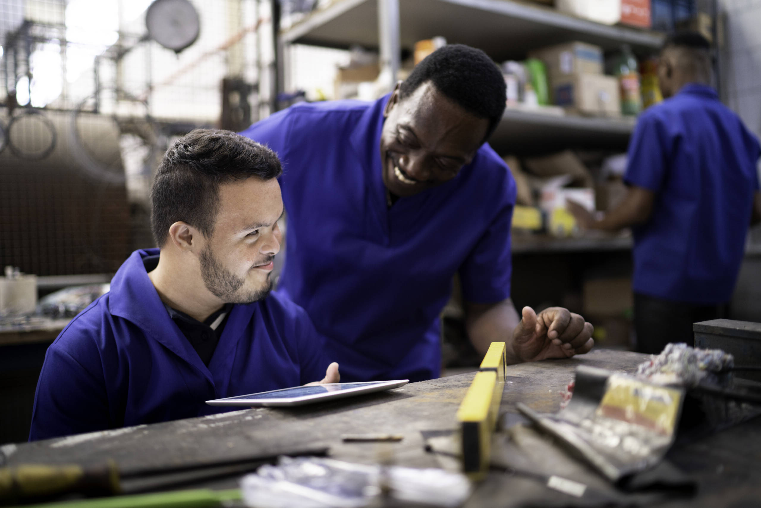 Two young male coworkers talking in GCE Designs production shop