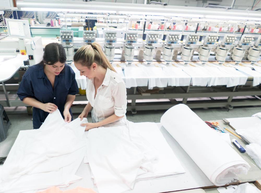 Two women working at an embroidery machine